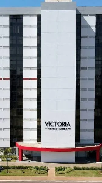 Fachada do Edifício Victoria Office Tower, com o letreiro do prédio e a marquise vermelha na entrada